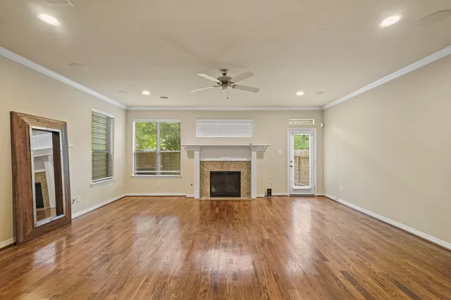 wooden floor fireplace and windows in an empty room