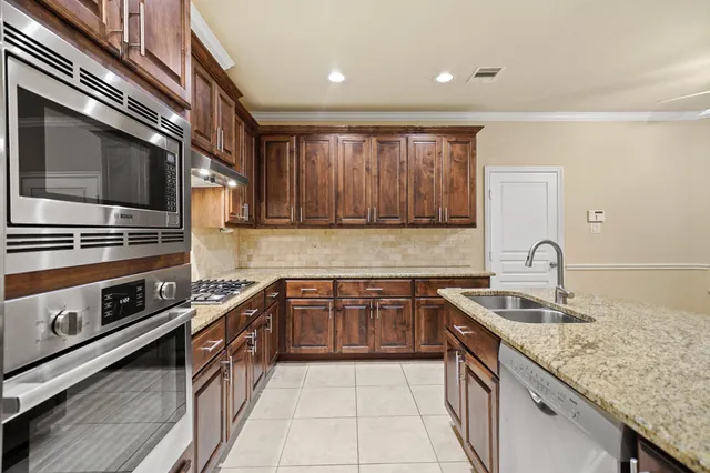 a kitchen with stainless steel appliances granite countertop a sink and a stove