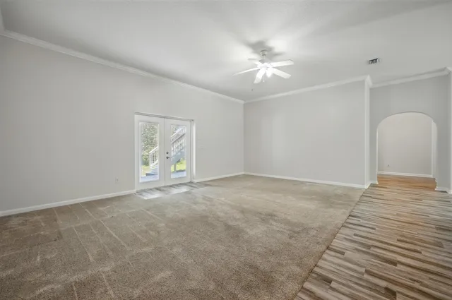 a view of empty room with kitchen and window
