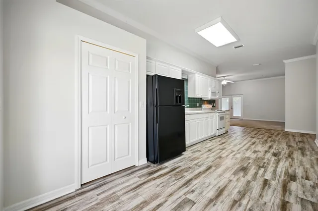 a kitchen with granite countertop white cabinets and white appliances
