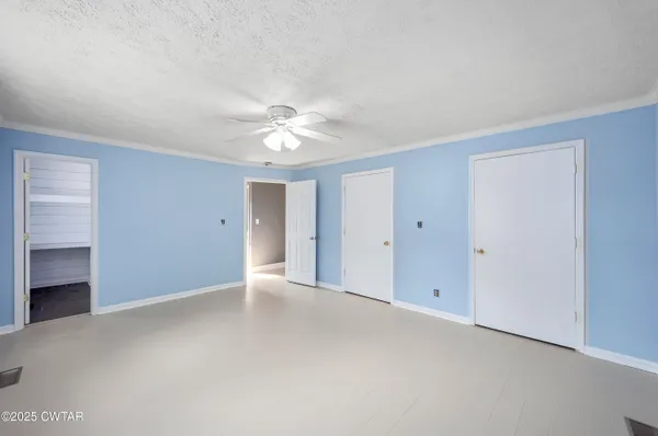 a view of an empty room with a ceiling fan