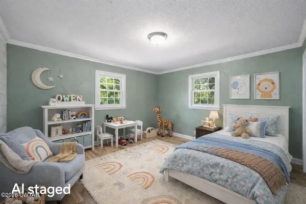 a bedroom with a bed wooden floor and a window