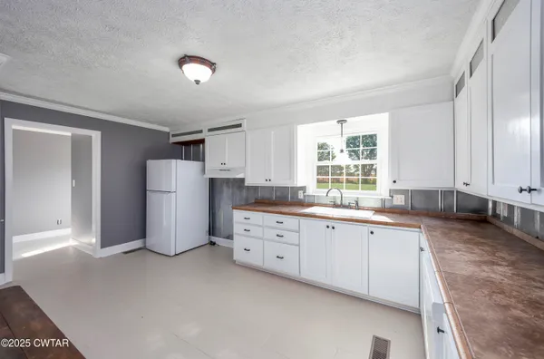 a kitchen with sink a refrigerator and cabinets