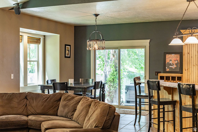 288 525 South Providence, UT 84332 - Photo 11 of 71 Open concept living area featuring a sliding glass door, a built-in bar with wood paneling, a dining area with a window, and recessed lighting