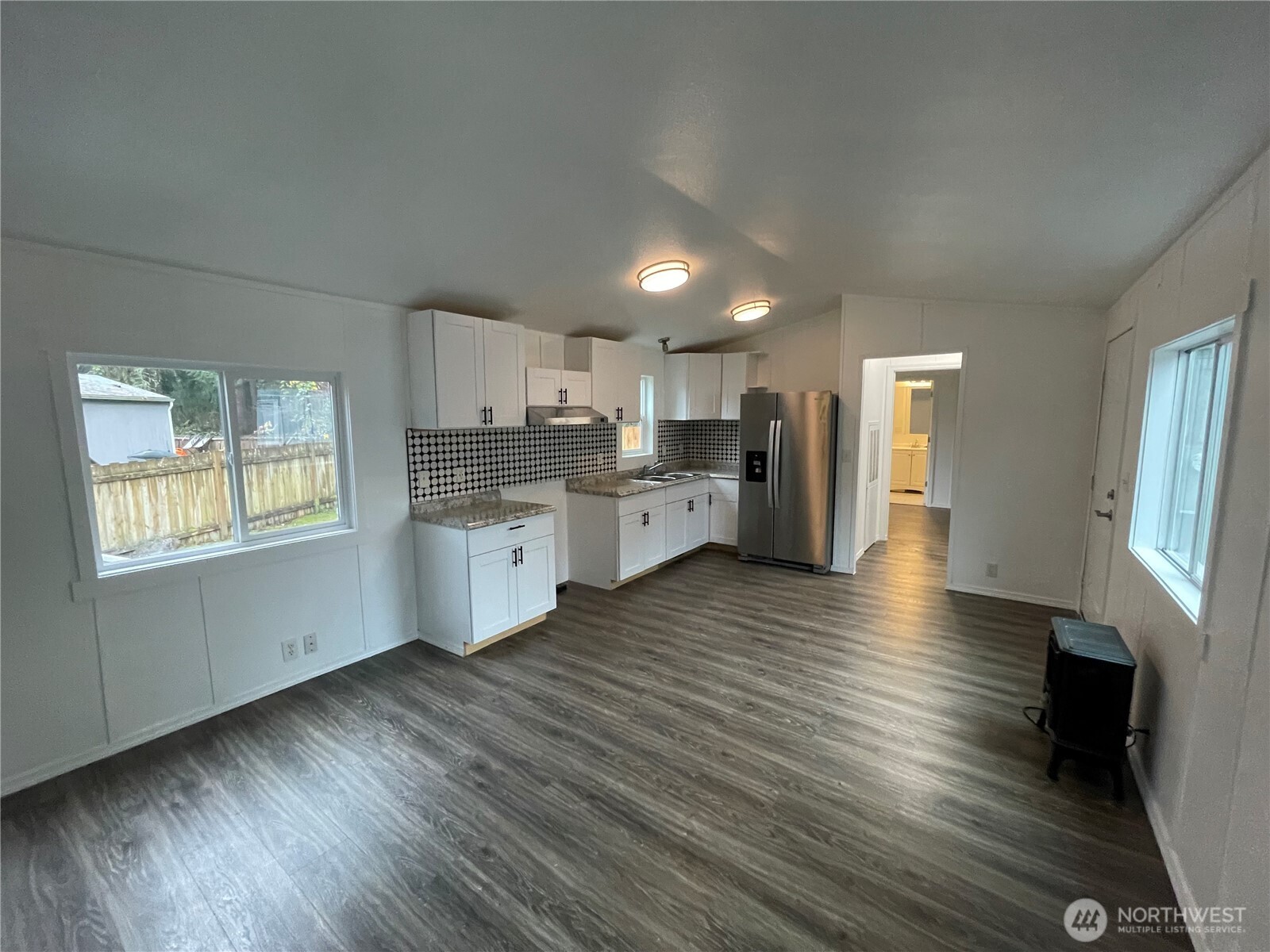 5705 Littlerock Road Southwest, Unit 16 Tumwater, WA 98512 - Photo 13 of 18 a kitchen with stainless steel appliances granite countertop a stove a sink dishwasher and a refrigerator with wooden floor