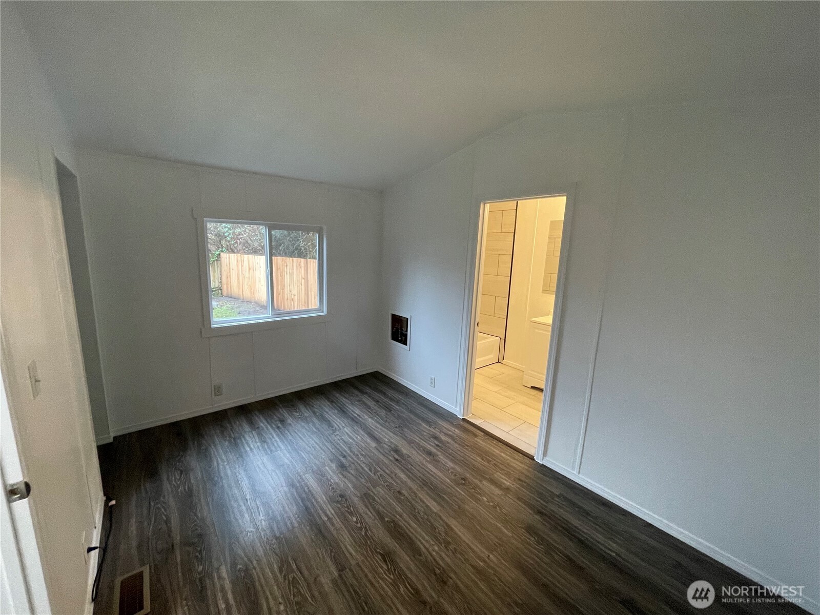 5705 Littlerock Road Southwest, Unit 16 Tumwater, WA 98512 - Photo 17 of 18 a view of an empty room with wooden floor and a window