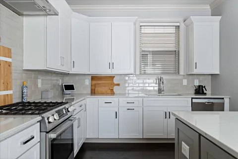a kitchen with granite countertop white cabinets and white appliances