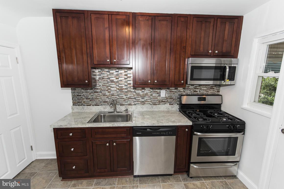 1902 Jasmine Road Baltimore, MD 21222 - Photo 7 of 27 a kitchen with wooden cabinets and a stove top oven