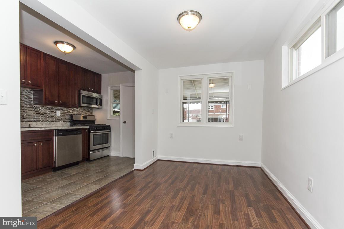 1902 Jasmine Road Baltimore, MD 21222 - Photo 8 of 27 a kitchen with wooden floors and wooden cabinets