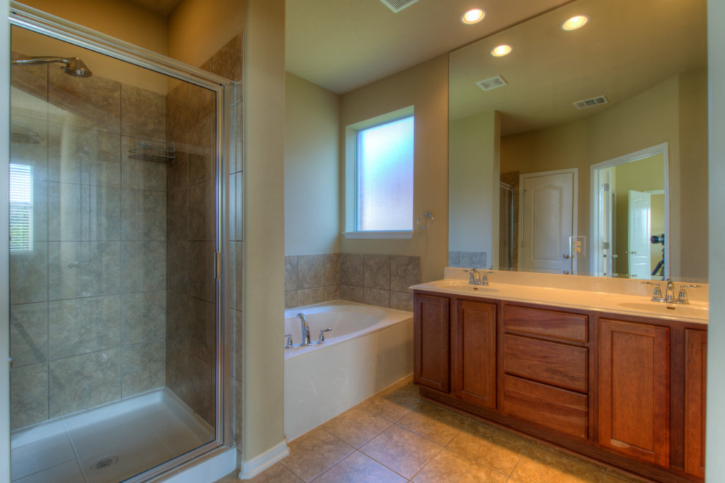 403 Limestone Trail Austin, TX 78737 - Photo 15 of 18 Luxurious primary bath showcasing a spacious soaking tub, separate shower, and dual vanity.