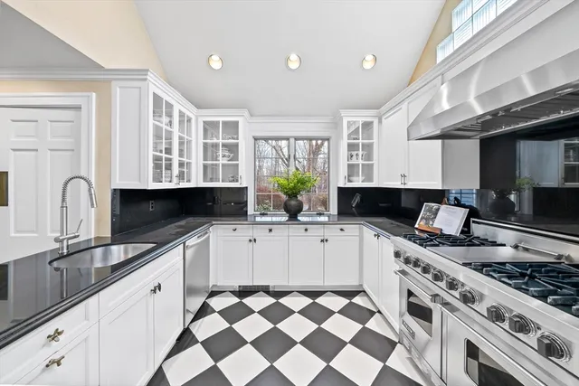 a kitchen with stainless steel appliances a sink a stove a refrigerator and window