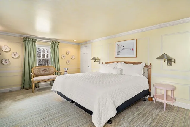 a large bedroom with a bed wooden floor and window