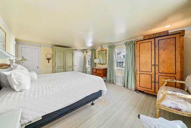 a bedroom with a large bed and wooden floor