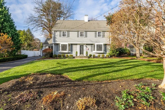 a front view of a house with a yard and trees