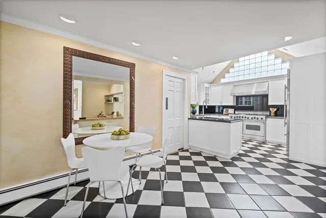 a kitchen with a sink a stove and white cabinets with wooden floor