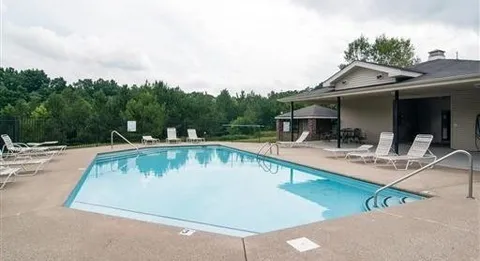 a view of swimming pool with outdoor seating and house in the background