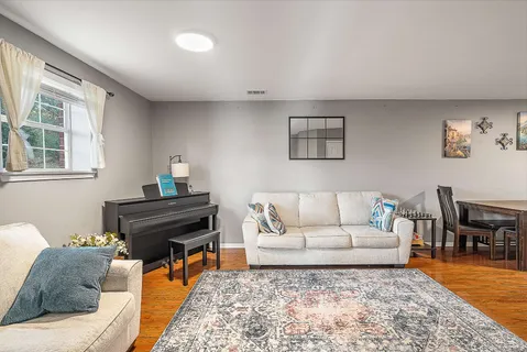 a living room with furniture and a piano