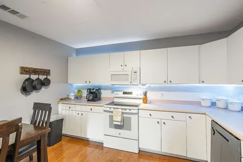 a kitchen with white cabinets and white appliances