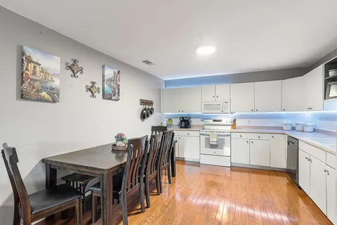 a kitchen with a table chairs cabinets and wooden floor