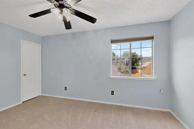 en empty room with window and ceiling fan