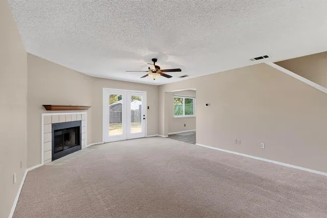 a view of an empty room with a fireplace and a window