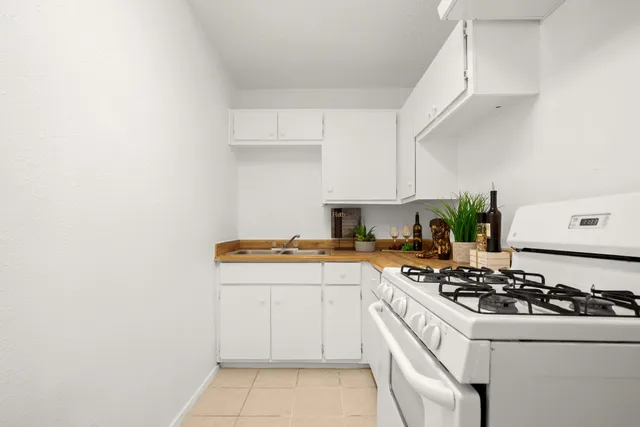 a kitchen with a white stove and white cabinets