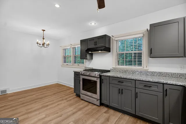 a kitchen with granite countertop a stove and a wooden floors