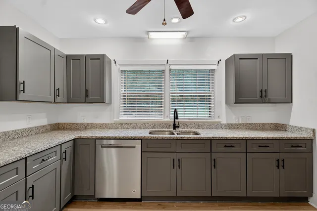 a kitchen with granite countertop cabinets stainless steel appliances a sink and a window