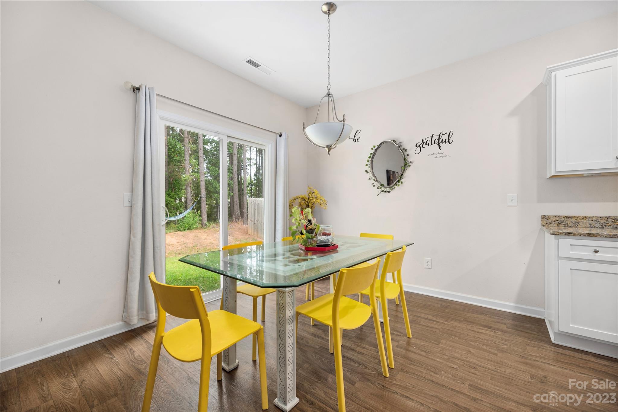 6415 Jerimoth Charlotte, NC 28215 - Photo 11 of 22 a dining room with furniture a chandelier and wooden floor