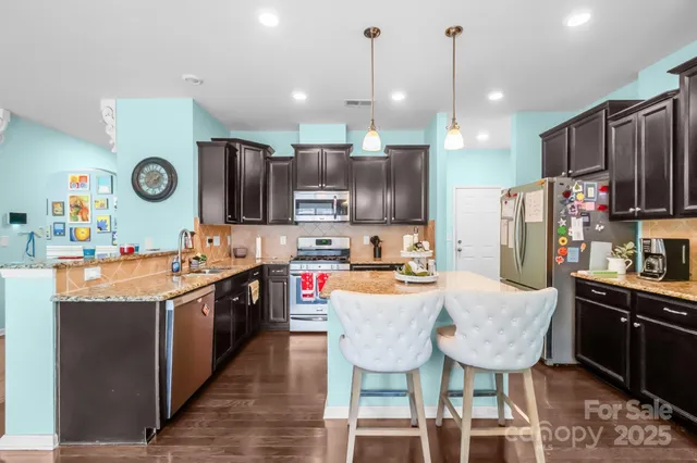 a kitchen with granite countertop a sink a counter space appliances and cabinets