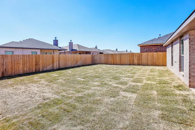 a view of a backyard with wooden fence