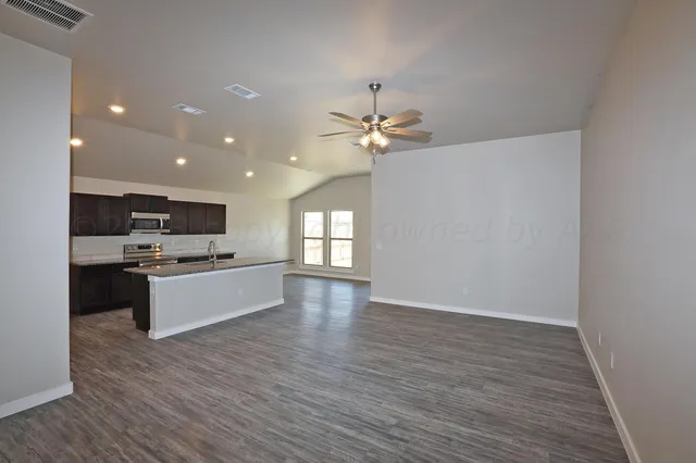 a large kitchen with a large counter top a sink and a stove