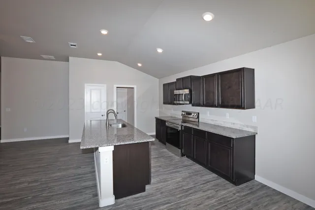 a large kitchen with stainless steel appliances lots of counter space and wooden floor