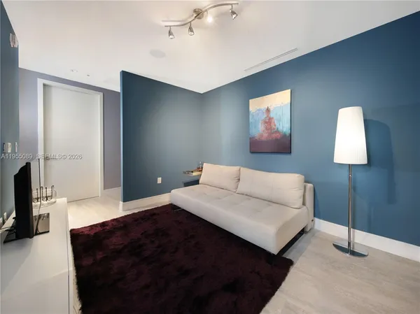 a living room with furniture a lamp and a flat screen tv