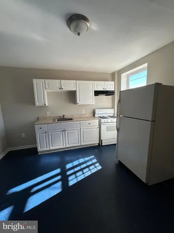 a kitchen with a refrigerator and a stove top oven