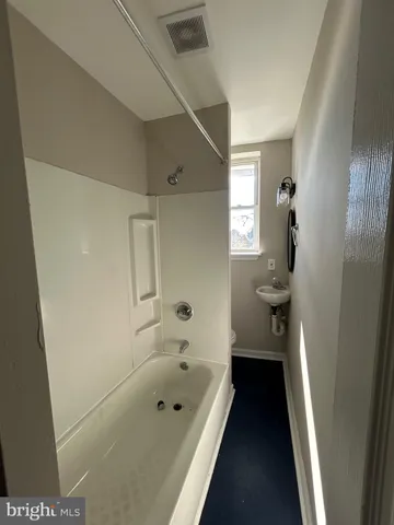 a bathroom with a tub sink and toilet