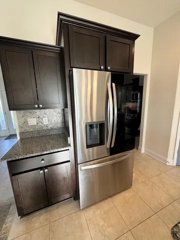 a metallic refrigerator freezer sitting in a kitchen