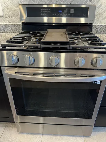 a stove top oven sitting inside of a kitchen