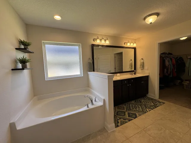 a bathroom with a bathtub sink and mirror