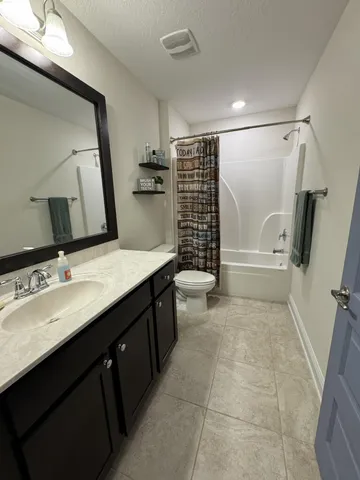 a bathroom with a sink a toilet a mirror and shower