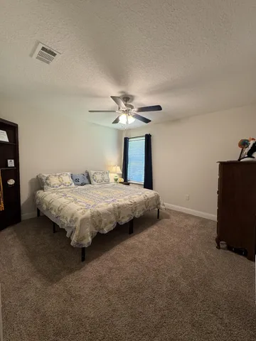 a spacious bedroom with a bed and a chandelier