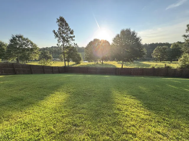 a view of yard with swimming pool and green space