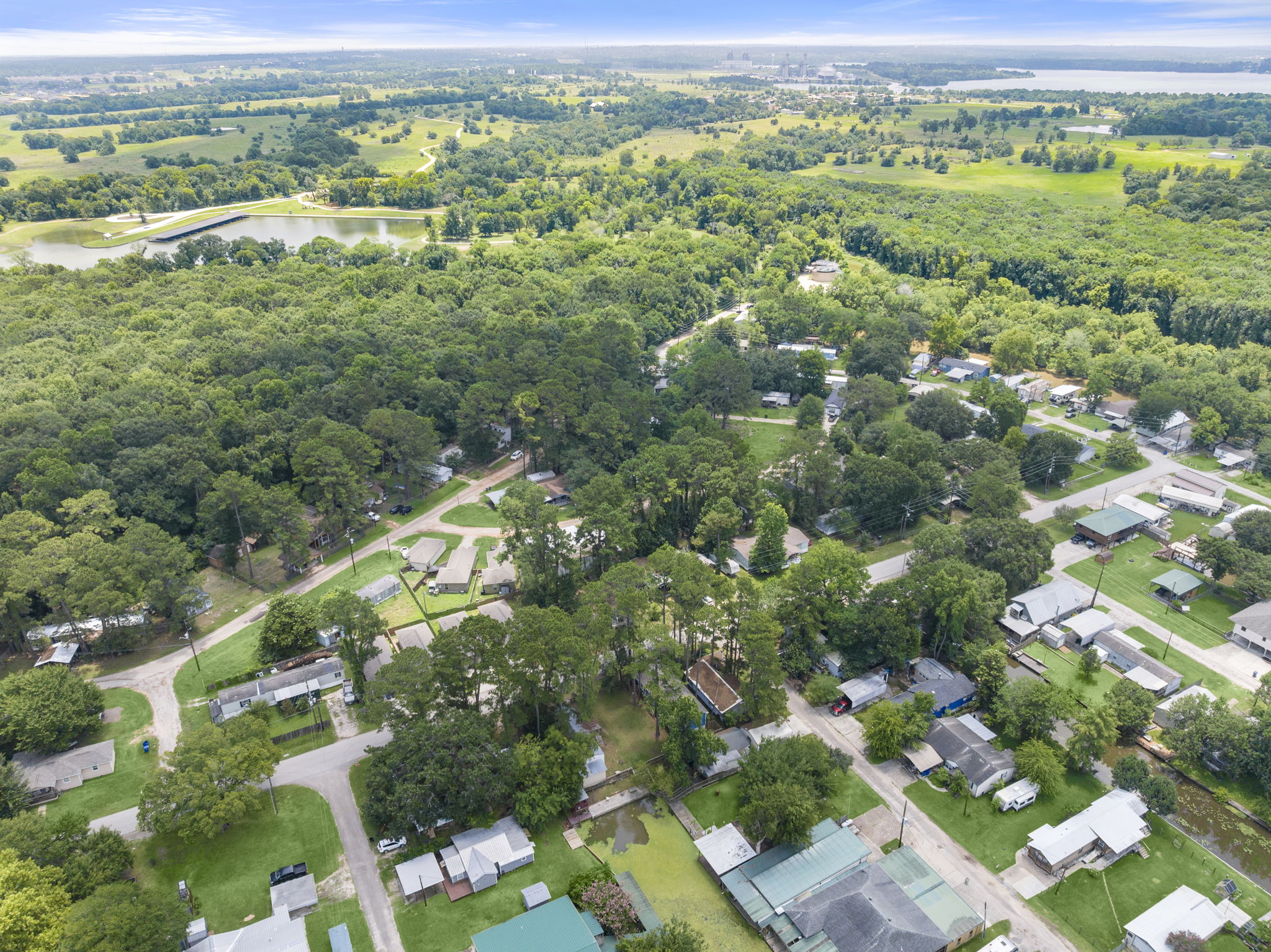 9649 Warm Spring Willis, TX 77318 - Photo 26 of 30 An aerial perspective reveals a serene community nestled amidst dense woodlands and bordering tranquil waters.