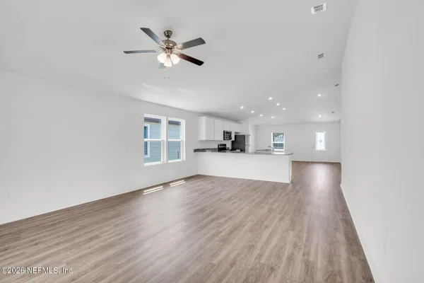 a view of empty room with wooden floor and window