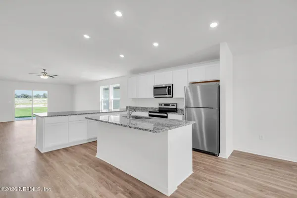 a kitchen with stainless steel appliances a refrigerator and a stove top oven