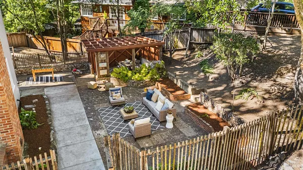 a view of a house with a small yard and potted plants