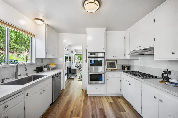 a view of a hallway with wooden floor and furniture