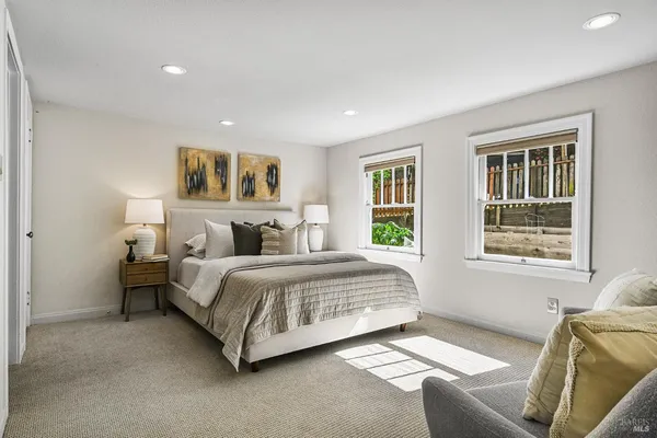a spacious bedroom with a large bed and a painting on the wall