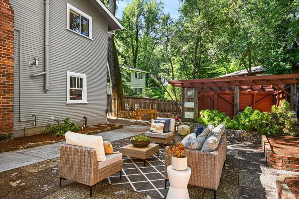 a backyard of a house with barbeque oven and plants