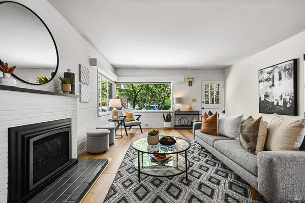 a living room with furniture a fireplace and a large window